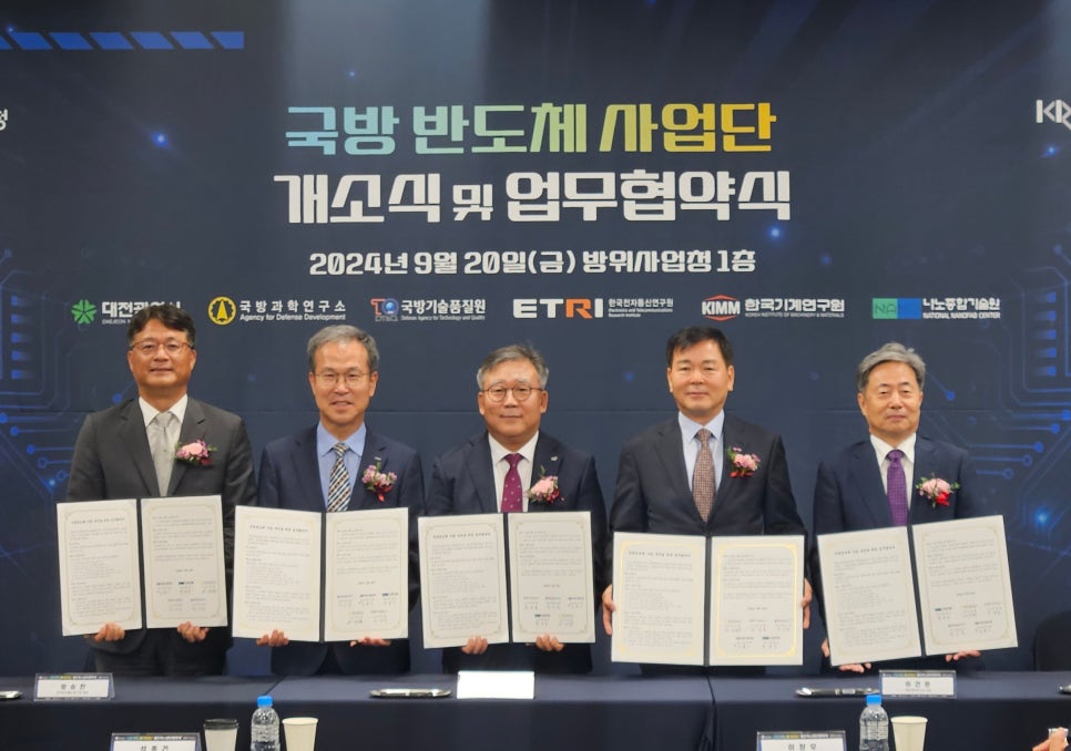 한국기계연구원-국방기술진흥연구소 협력 협약식 중 협약문을 들고있는 사진