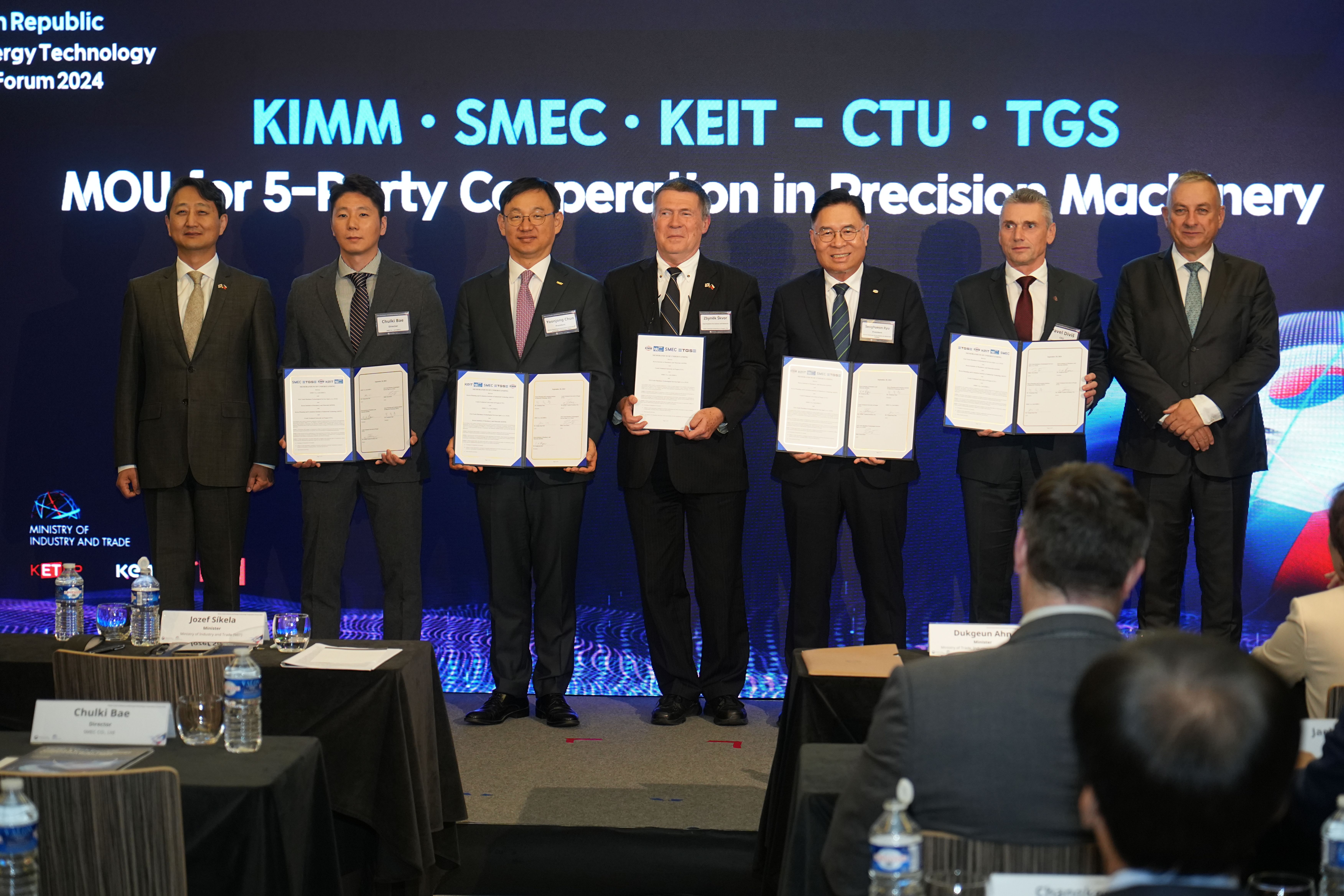 기계연-KEIT-CTU-SMEC-TGS 정밀기계분야 5자 협약식 중 협약문을 들고있는 사진